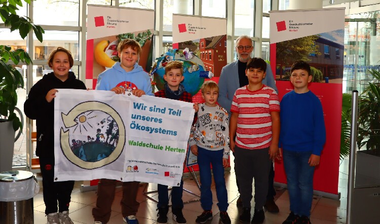 Kinder der 4a der Waldschule Herten stellen ihre Erde in der Stadtbücherei aus, die sie aus Müll gebaut haben.